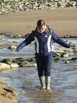 SX17195 Jenni walking through stream on Llantwit Major beach.jpg